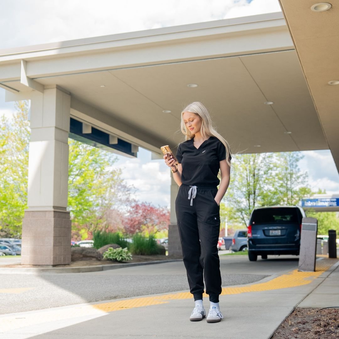 Nurse standing outside hospital looking at her schedule using the litehouse app